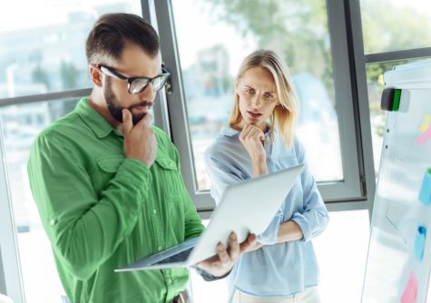 Ein Mann und eine Frau schauen sich Informationen auf einem Notebook an.