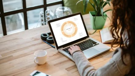 Eine Frau sitzte an einem Schreibtisch vor einem offene Laptop und bedient die Software.