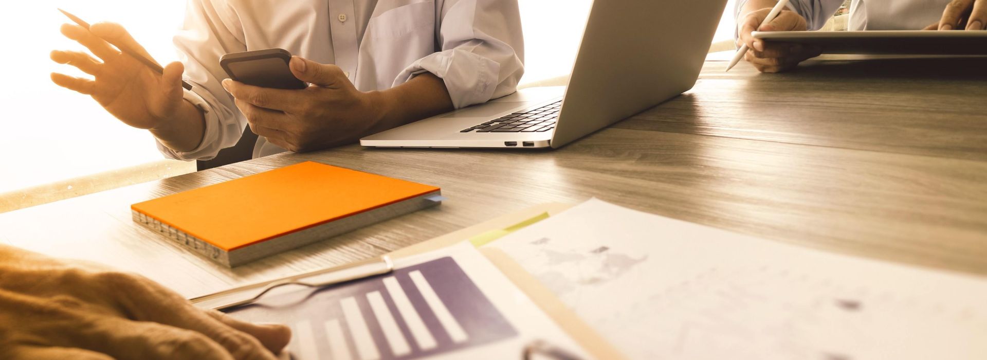 Mediziner unterhalten sich am Tisch mit Laptop und Handy über Informationen