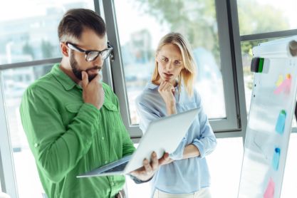 Ein Mann und eine Frau schauen sich Informationen auf einem Notebook an.